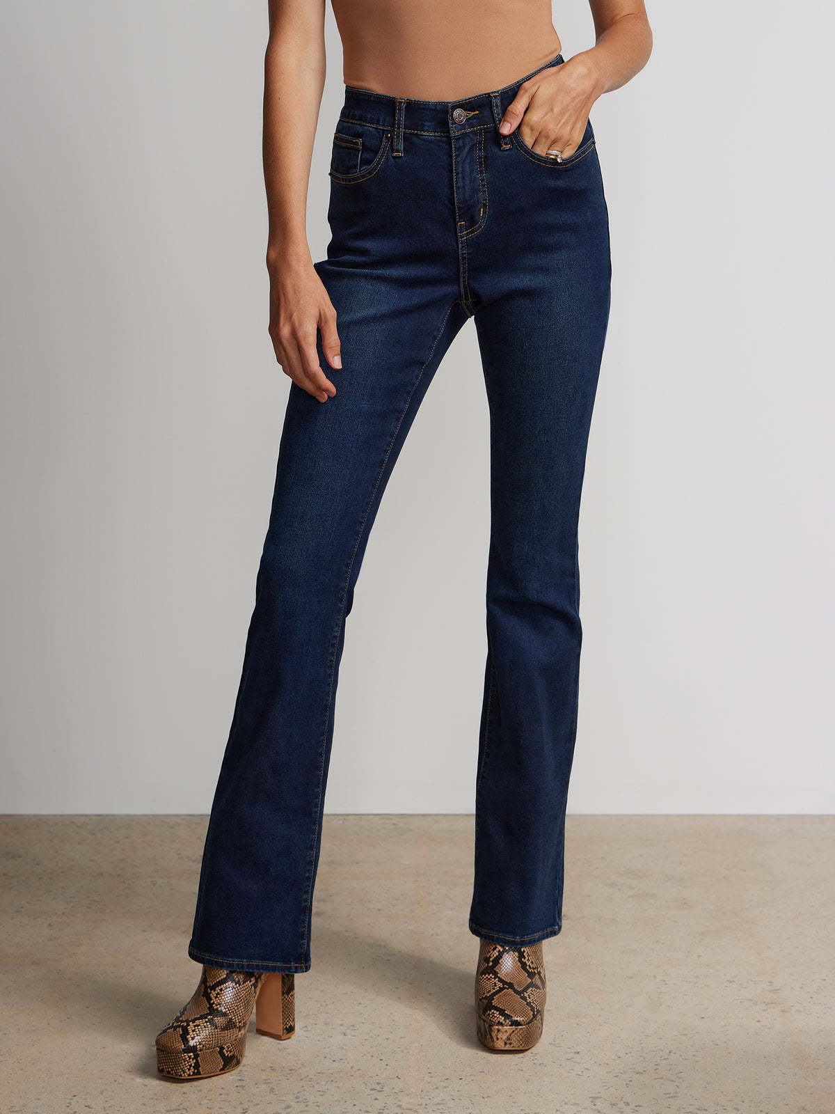 Tan stiletto boots with high-waisted dark jeans
